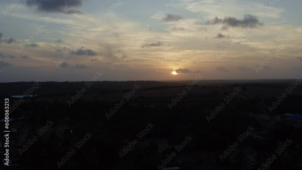 Rising aerial drone extreme wide landscape shot of a beautiful orange golden sunset over the small beach town of Sibauma in Tibau do Sul, Rio Grande do Norte, Brazil during a warm sunny summer sunset Rising aerial drone extreme wide landscape shot of a beautiful orange golden sunset over the small beach town of Sibauma in Tibau do Sul, Rio Grande do Norte, Brazil during a warm sunny summer sunset