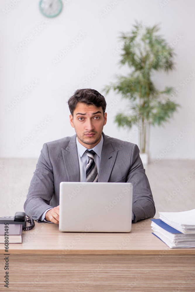 Young male employee working in the office Young male employee working in the office