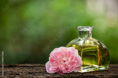 Damask rose flower and oil on nature background.