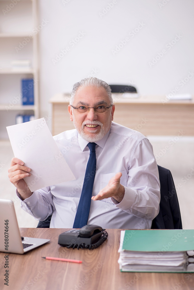 Old male employee working in the office Old male employee working in the office