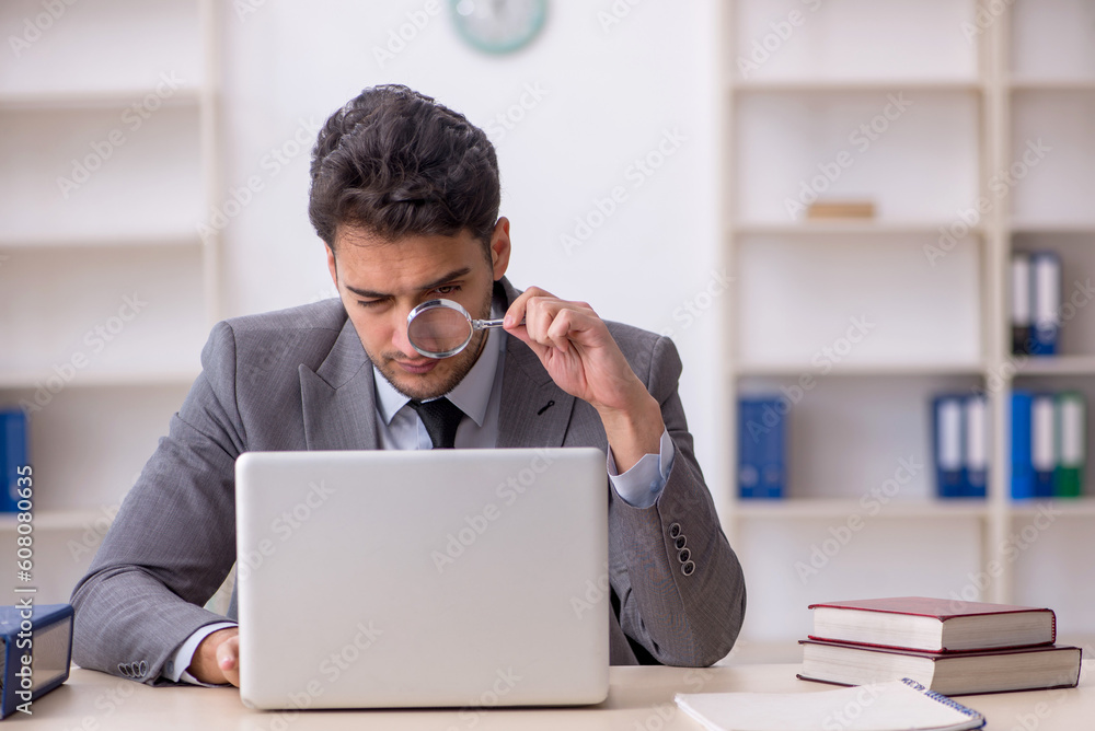 Young male employee working in the office Young male employee working in the office