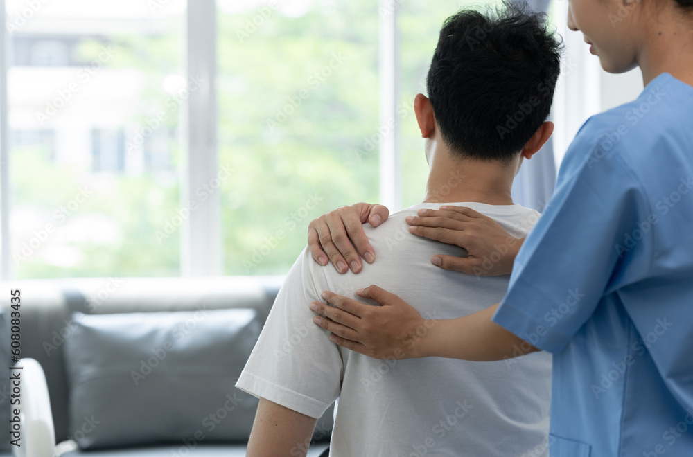 A physiotherapist or medical professional doing physiotherapy on the back scapula and back injury of male athlete patient stretching and exercise cause pain rehabilitation therapy, health insurance. A physiotherapist or medical professional doing physiotherapy on the back scapula and back injury of male athlete patient stretching and exercise cause pain rehabilitation therapy, health insurance.