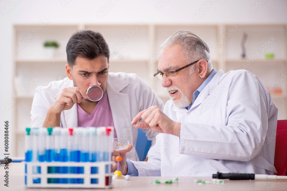 Two male chemists working at the lab Two male chemists working at the lab
