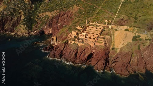 Establishing shot of epic steep coast of Nebida with ruins of mining industry photo