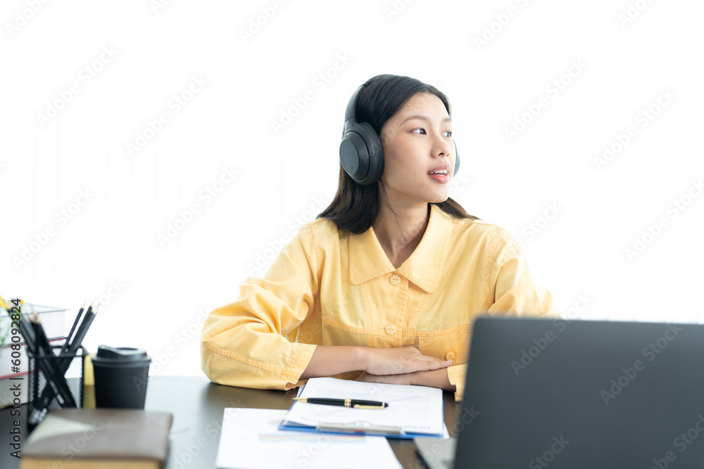 Attractive young Asian business woman relaxing from work during break listening to music and having fun. on white background Attractive young Asian business woman relaxing from work during break listening to music and having fun. on white background