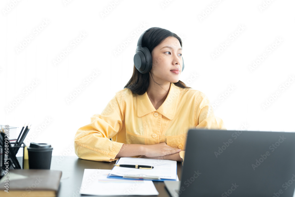 Attractive young Asian business woman relaxing from work during break listening to music and having fun. on white background Attractive young Asian business woman relaxing from work during break listening to music and having fun. on white background