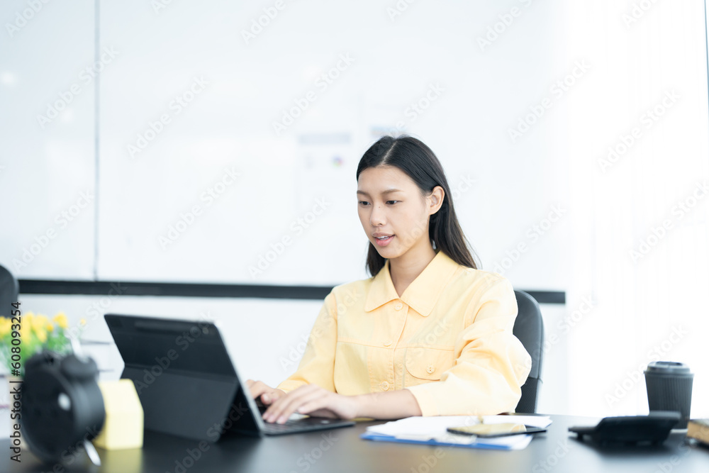 Portrait of pretty cheerful girl smiling while working on laptop in office Portrait of pretty cheerful girl smiling while working on laptop in office