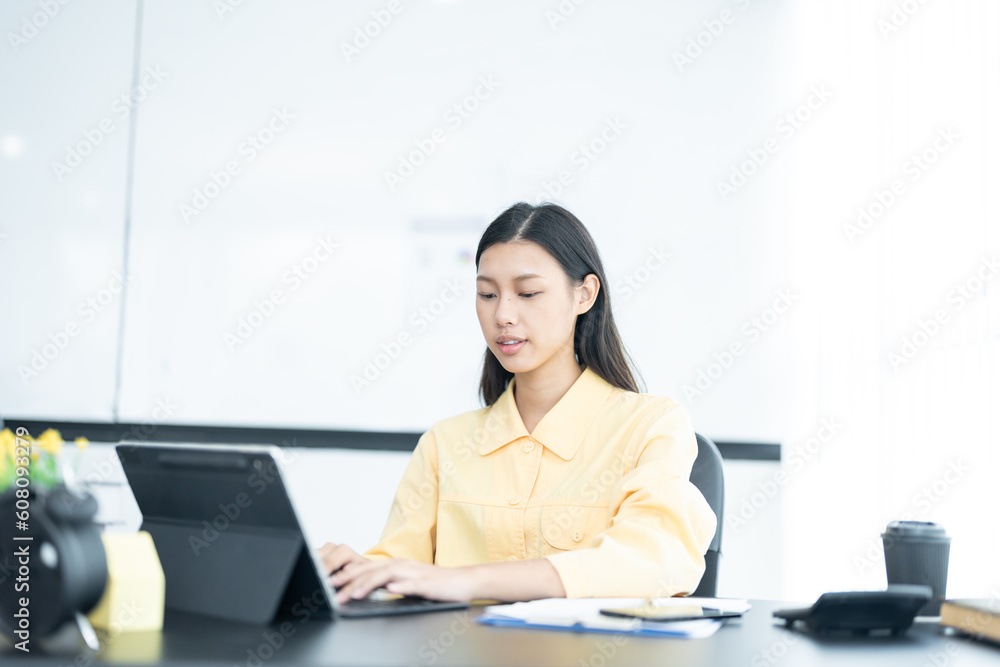 Portrait of pretty cheerful girl smiling while working on laptop in office Portrait of pretty cheerful girl smiling while working on laptop in office