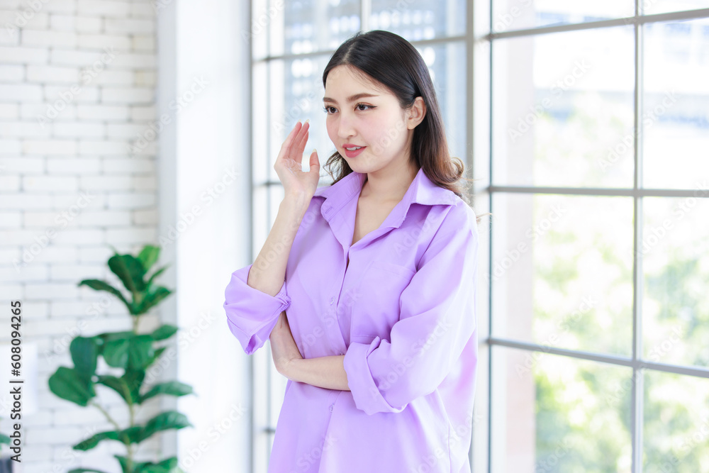 Millennial Asian beautiful cheerful happy female model in casual long sleeve purple shirt outfit and jeans shorts standing crossed arms leaning glass windows smiling to studio camera in living room Millennial Asian beautiful cheerful happy female model in casual long sleeve purple shirt outfit and jeans shorts standing crossed arms leaning glass windows smiling to studio camera in living room