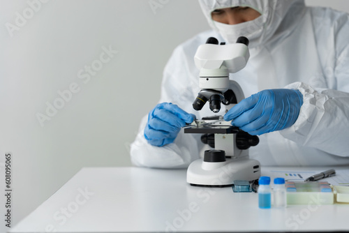 medical research laboratory Scientist, medical researcher looking through a microscope, digital tablet, analyzing solution sample in laboratory for education.