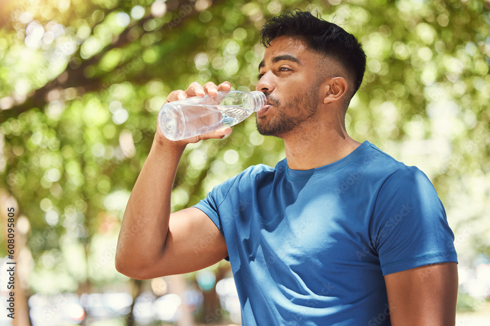 Fitness, man or runner drinking water outdoor for exercise, training or running at a park. Indian male athlete in nature for a workout, run and break to drink from a bottle for health and wellness Fitness, man or runner drinking water outdoor for exercise, training or running at a park. Indian male athlete in nature for a workout, run and break to drink from a bottle for health and wellness
