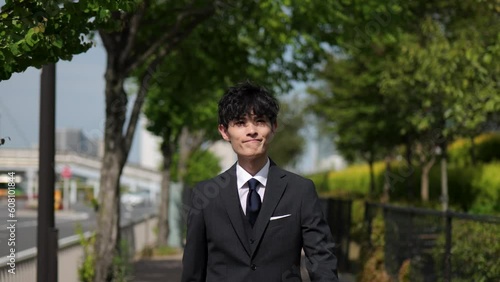 Wallpaper Mural 木洩れ日の歩道を歩く笑顔のビジネスマンのトラッキングショット Torontodigital.ca