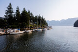 Boats at dock at the mouth of Snug Cove, Bowen Island looking to Howe Sound and Coast Mountains in the morning sun