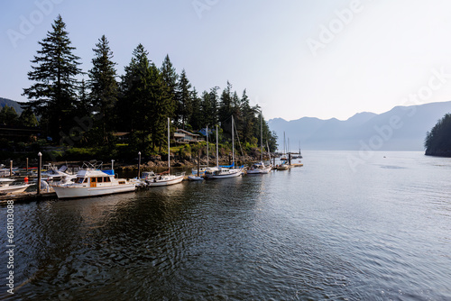 Boats at dock at the mouth of Snug Cove, Bowen Island looking to Howe Sound and Coast Mountains in the morning sun photo