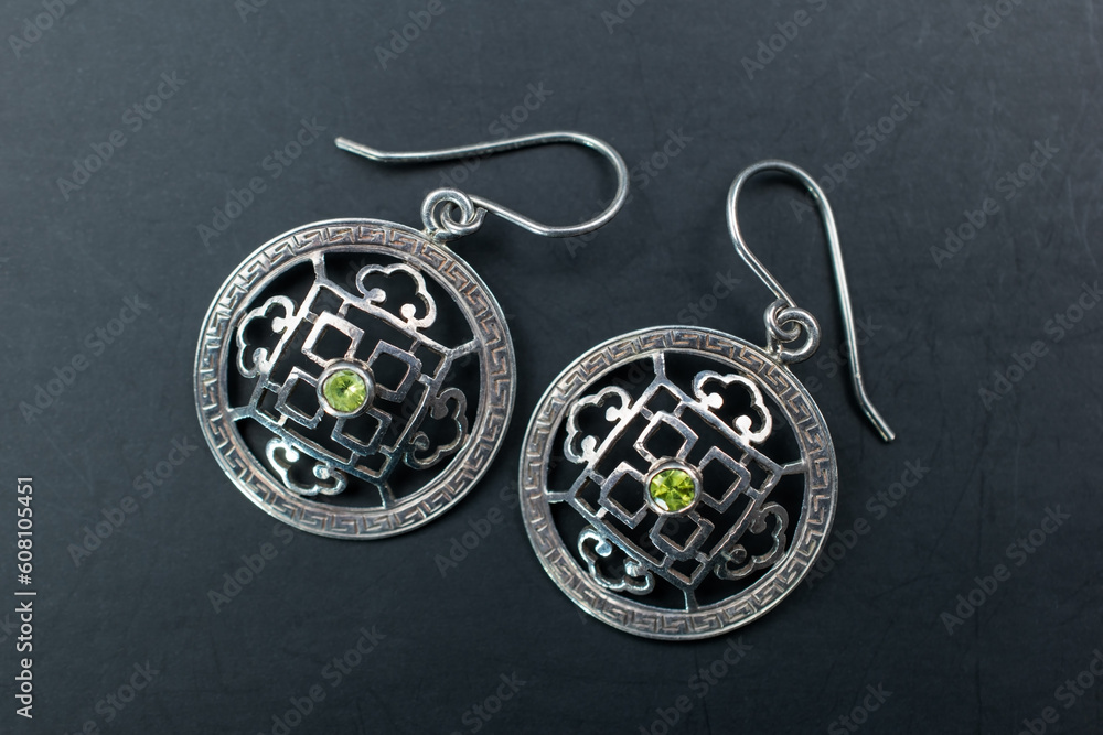 Vintage silver earrings with green gemstones close up, retro jewelry concept, promotional photo for an online jewelry store