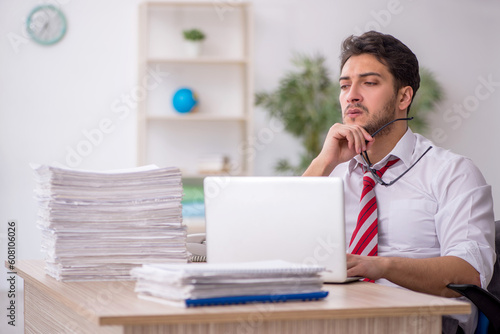 Young male employee and too much work in the office