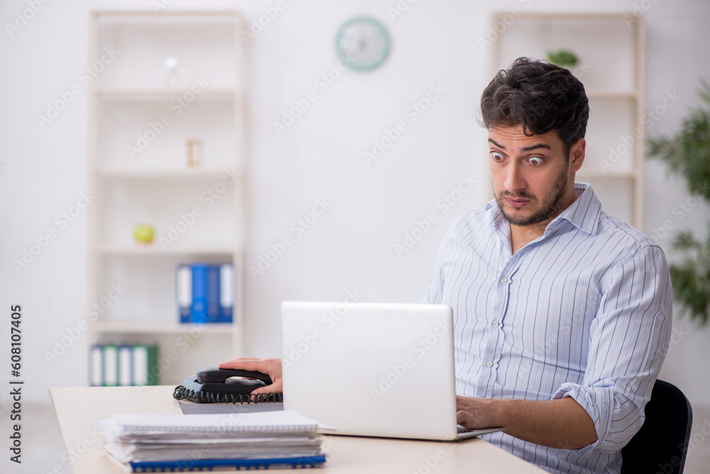 Young male employee working in the office Young male employee working in the office