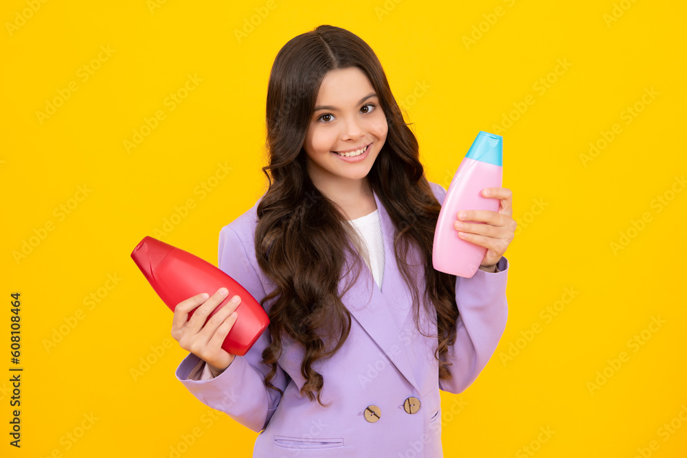 Teenager child girl showing bottle shampoo conditioners or shower gel. Hair cosmetic product. Bottle for advertising mock up copy space. Happy teenager, positive and smiling emotions of teen girl. Teenager child girl showing bottle shampoo conditioners or shower gel. Hair cosmetic product. Bottle for advertising mock up copy space. Happy teenager, positive and smiling emotions of teen girl.
