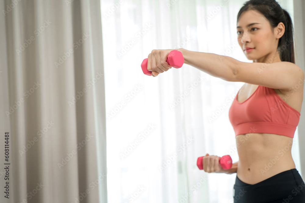 Sporty woman in sportswear doing exercise with dumbbells at home,Sport, Healthy lifestyle.