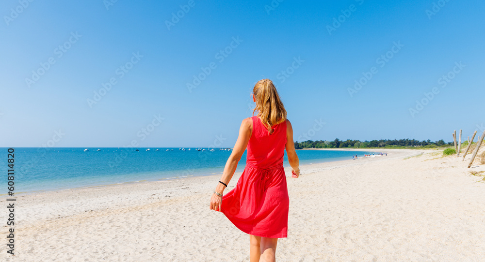 Woman with red dress walking on the beach- Brittany, Morbihan in France Woman with red dress walking on the beach- Brittany, Morbihan in France