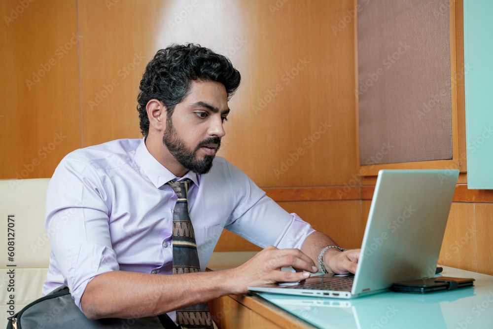 Indian businessman using laptop at office. Indian businessman using laptop at office.