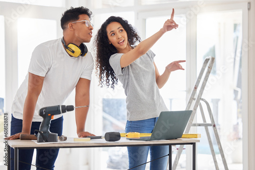 Laptop, renovation and planning with a couple in their new home together for a remodeling project. Construction, real estate or diy property improvement with a man and woman talking in their house