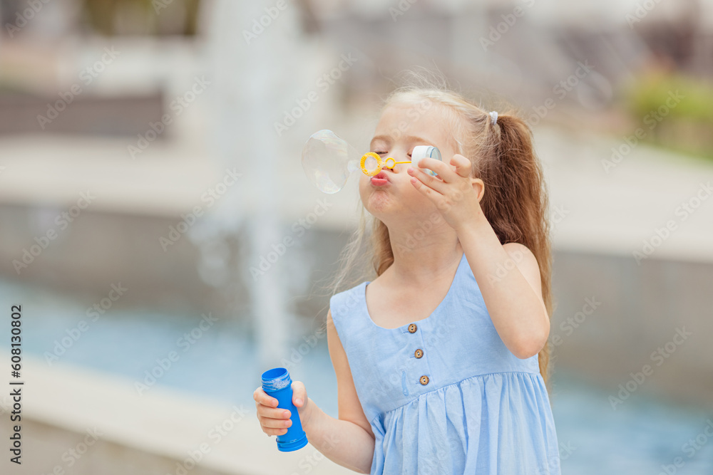Φωτογραφία Adorable Caucasian little girl in summer wear, standing near the city fountain a