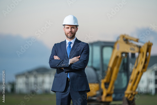 Worker in suit and helmet. Investor civil engineer, construction manager. Construction building developer at a construction site. Successful architect. Handsome hispanic builder man in suit.