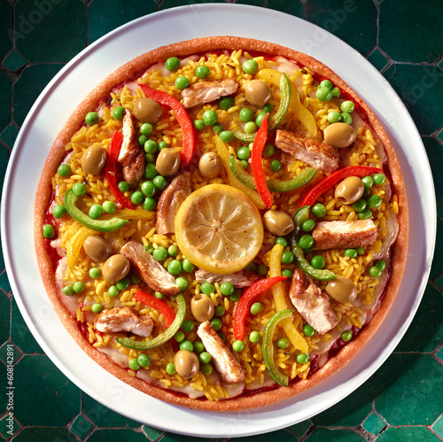 Pizza als Topshot mit Reis und Erbsen plus Paprika und Huehnchenstreifen dazu Zitrone.