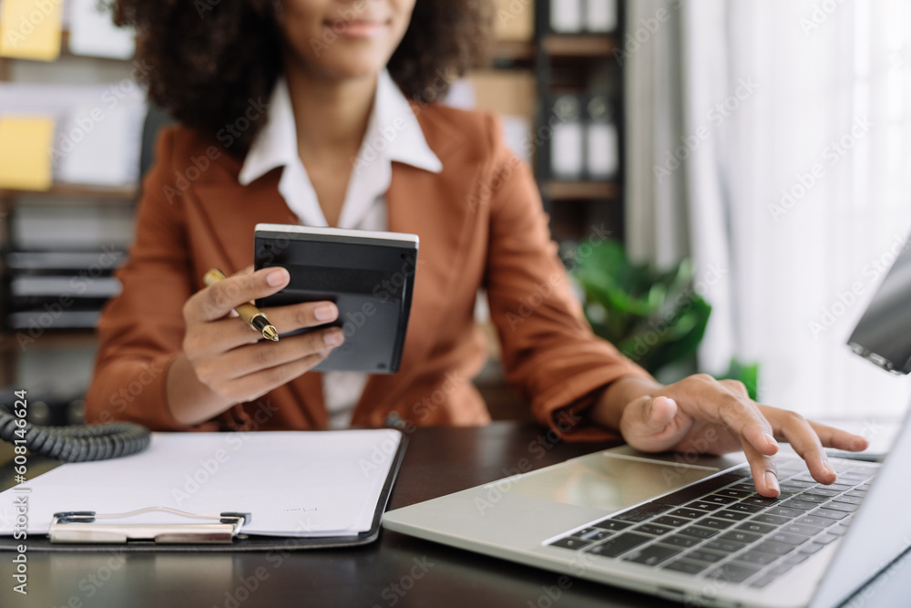 Businesswoman working with tablet and using a calculator to calculate the numbers of static in office. Finance accounting concept. Businesswoman working with tablet and using a calculator to calculate the numbers of static in office. Finance accounting concept.