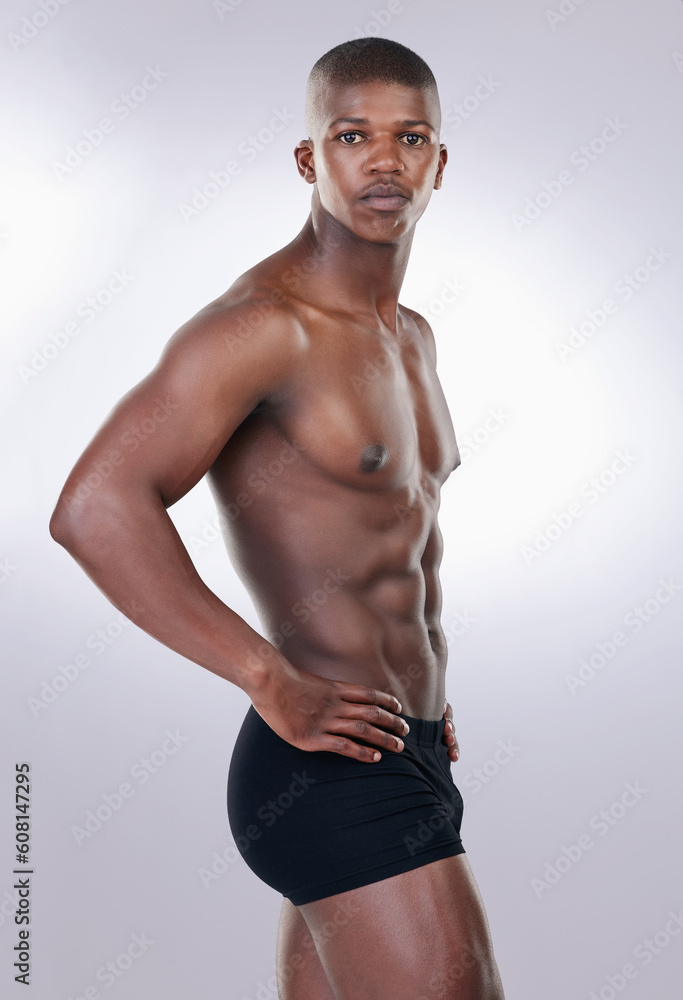 Attractive, confidence and portrait of a shirtless man in a studio with a muscular body in underwear. Serious, fitness and young African male model with a strong and sexy figure by white background.