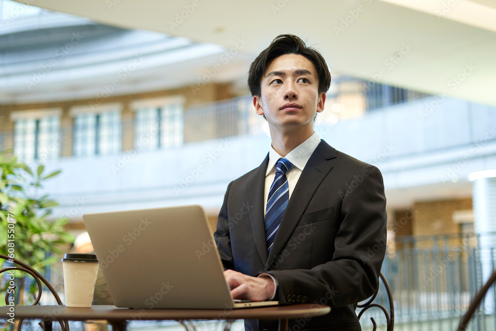 ノートパソコンを使用してリモートワークを行うスーツ姿の日本人ビジネスマン ノートパソコンを使用してリモートワークを行うスーツ姿の日本人ビジネスマン