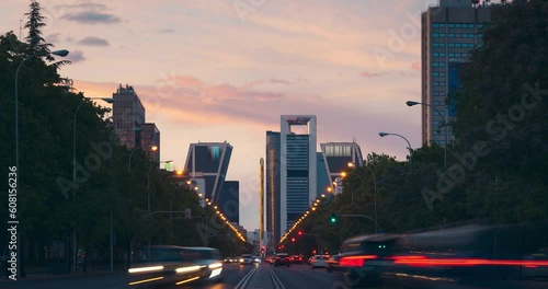 Paseo de la Castellana street timelapse with colorful sunset and rush hour traffic. photo