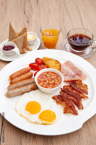 Full English breakfast set with sausage, egg, bacon, baked bean, ham, tomato and toast