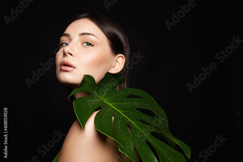 beautiful girl with palm leaves. Beautiful young woman with Make-up