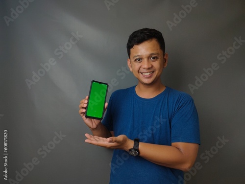 Young asian man shocked when he looking and pointing smartphone