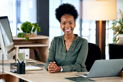 Portrait of happy black woman at desk with computer, smile and African entrepreneur with pride and tech. Confident businesswoman in office, small business startup and ceo at online management agency. photo