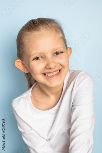 Protruding ears. Self acceptance. Beautiful girl. The girl smiles. Blue background.