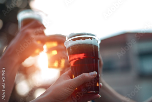 People holding beer cups and enjoying summertime outdoors.