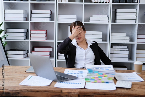 Asian woman working in office,young business woman stressed from work overload with a lot file on the desk,Thailand people thinking something