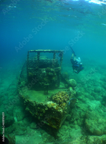 a diver exploring a small shipwreck on the island of Curacao