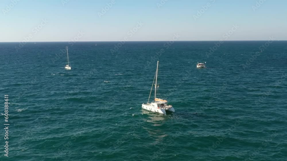 Aerial shot of a yacht sailing across the water Aerial shot of a yacht sailing across the water