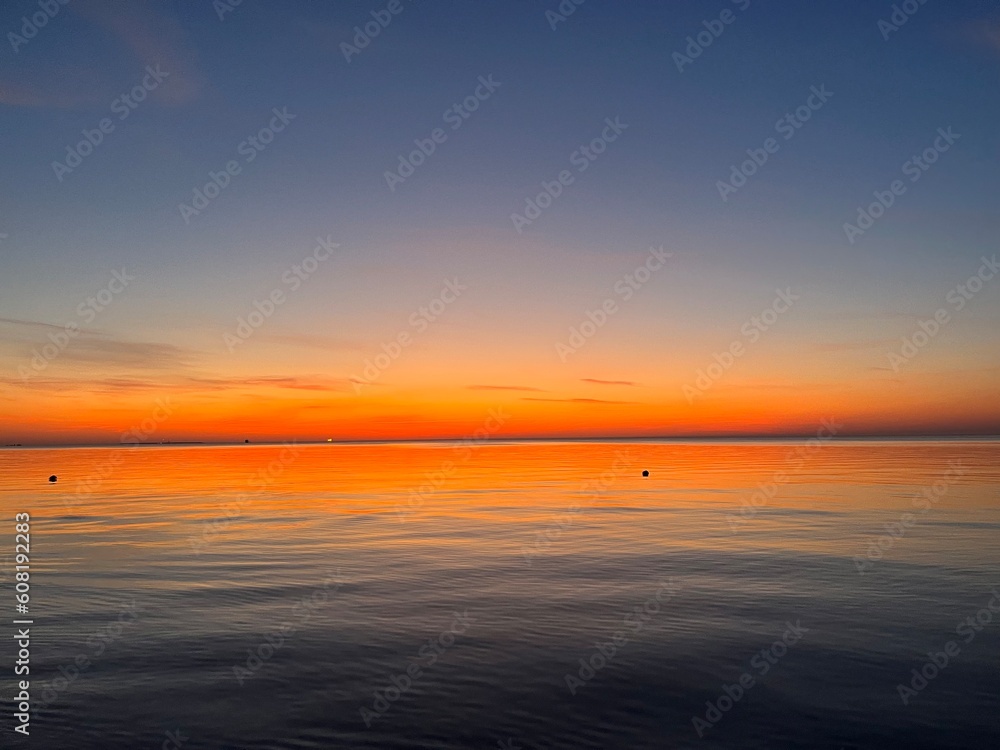 Orange sea horizon, seascape after the sunset, orange sunset reflection