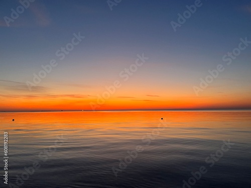 Orange sea horizon, seascape after the sunset, orange sunset reflection
