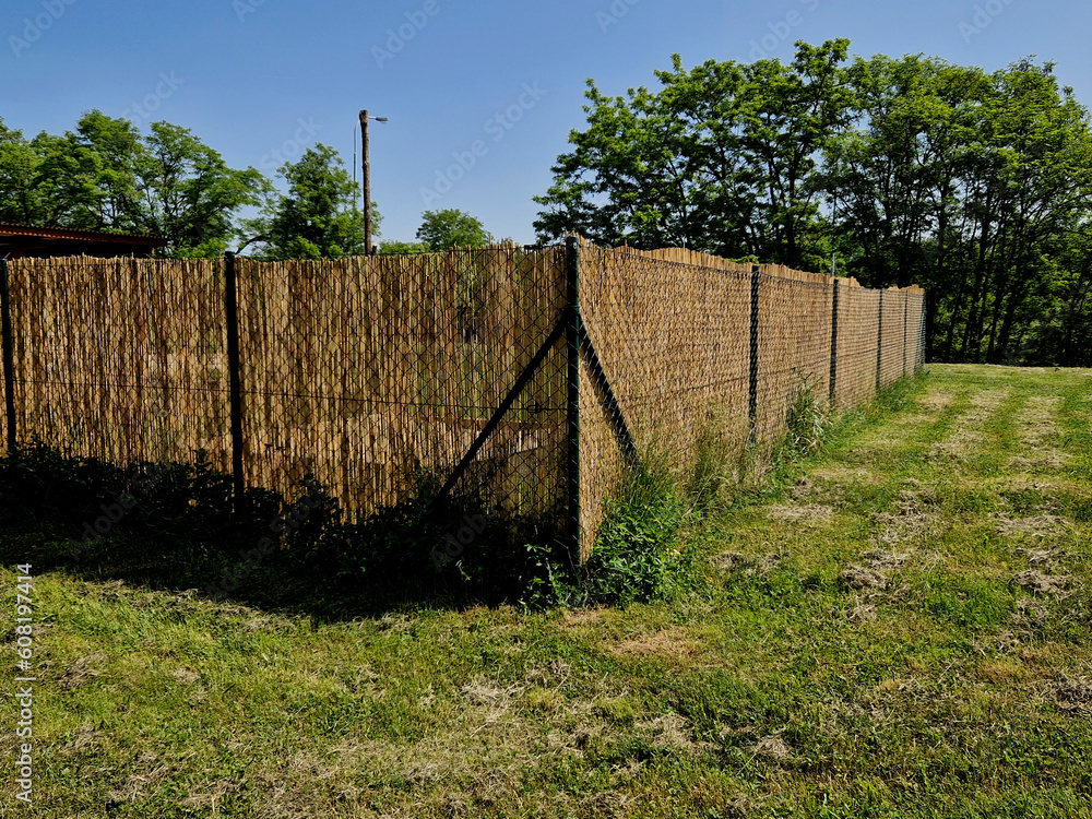 reed mat mats connected with wire mesh. attach to the wire fence and