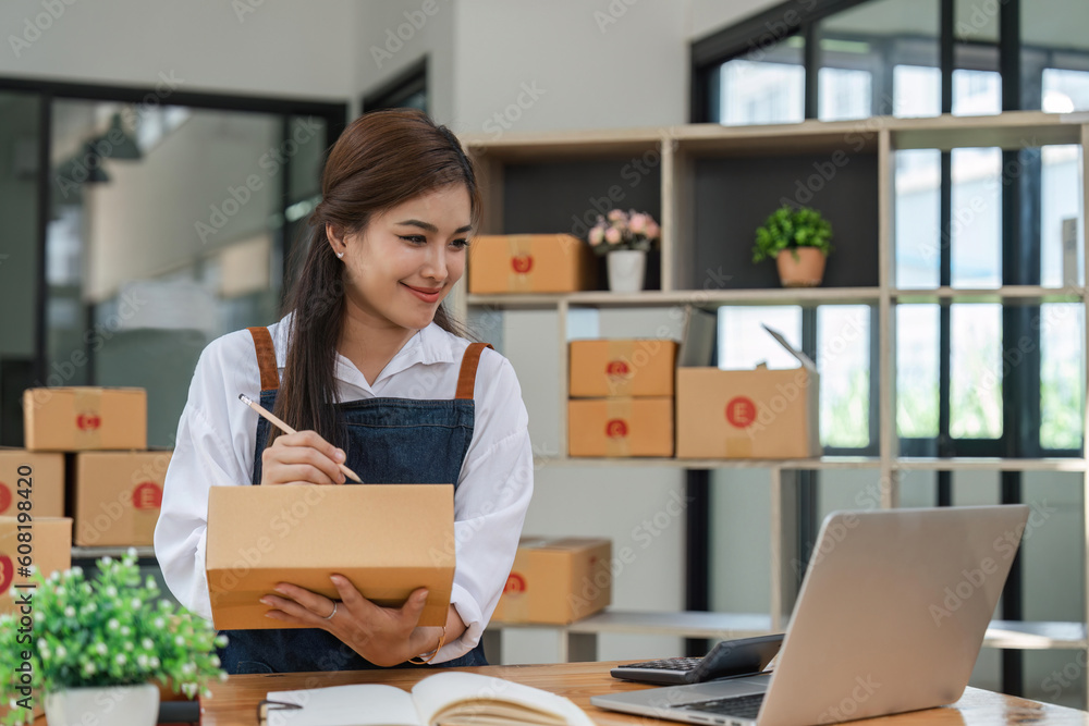 Business From Home Asian woman preparing package delivery box Shipping for shopping online. young start up small business owner at home online order Business From Home Asian woman preparing package delivery box Shipping for shopping online. young start up small business owner at home online order