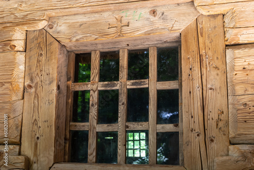 Window in a wooden house. wooden house with window frame. Old wooden house in the village, Wood board background, texture. Window with glass and frame wood and wooden home in rural or countryside