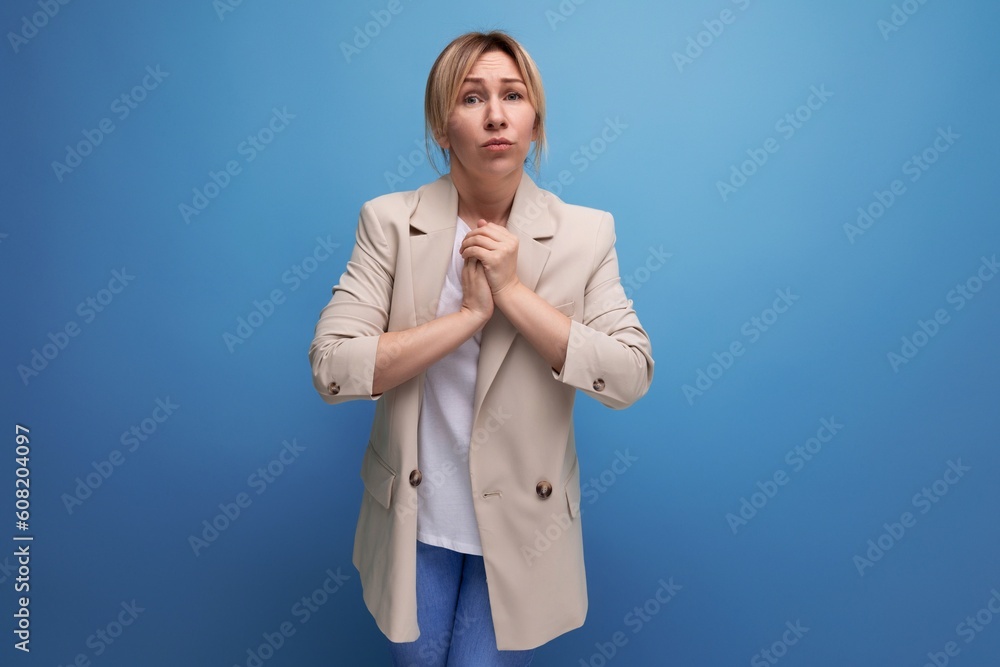 hopeful blonde young woman in jacket on studio background with copy space hopeful blonde young woman in jacket on studio background with copy space