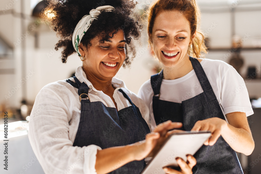 Fotografija Two restaurant workers using a touchscreen tablet together