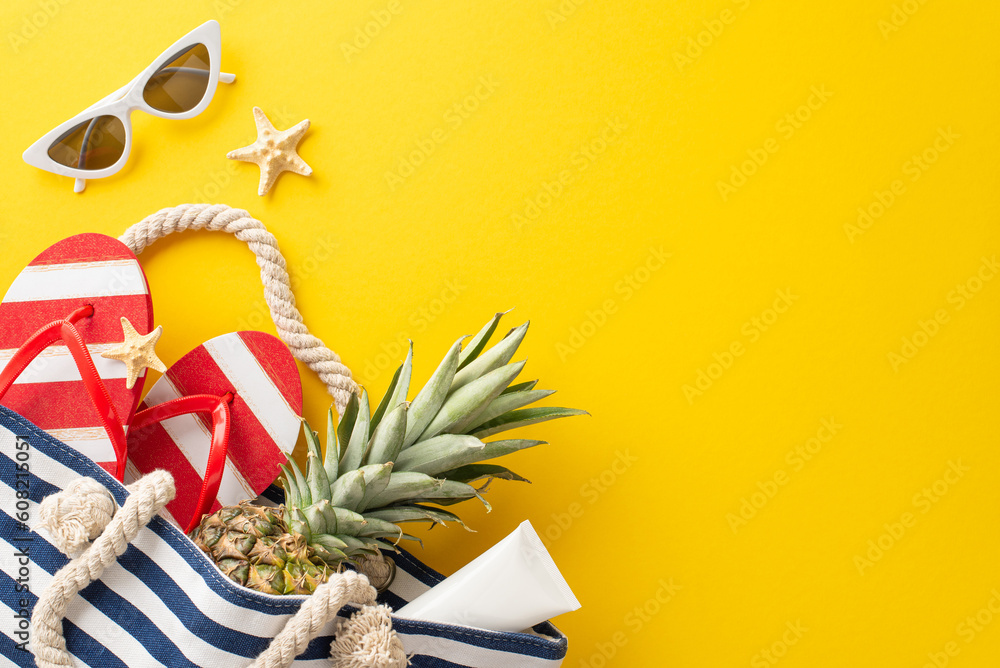 Immerse yourself in the summer vacation spirit with top view flat lay. Beach bag filled with pineapple, flip-flops, SPF lotion, and a seastar on a vibrant yellow background - obrazy, fototapety, plakaty 